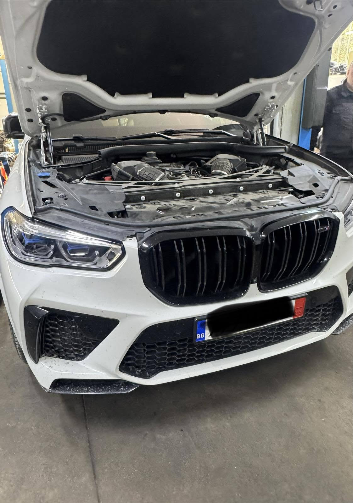 Бял BMW с монтиран обратно двигателя след ремонт